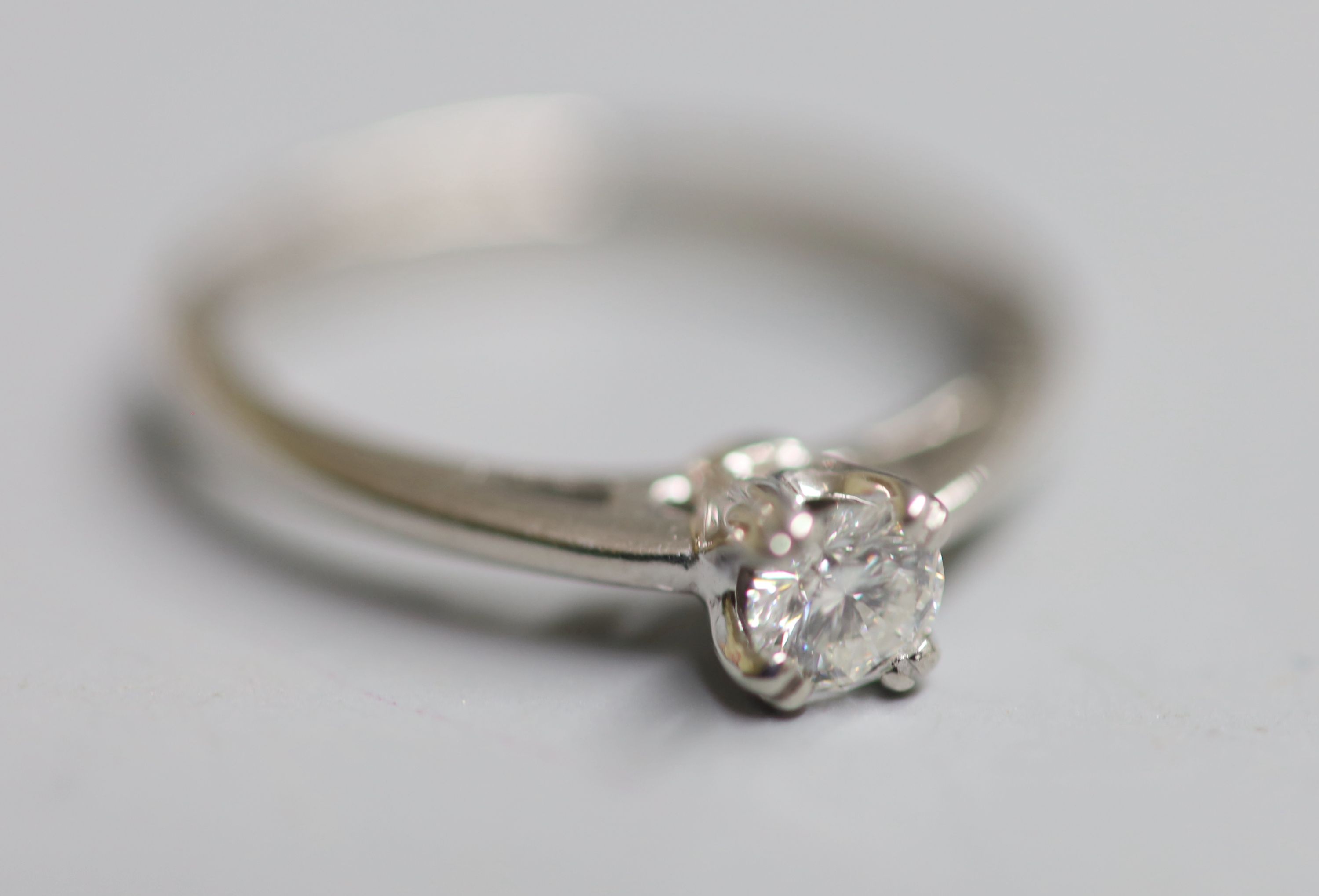 A modern white metal (stamped Plat) and solitaire diamond ring, size N, gross 4 grams,